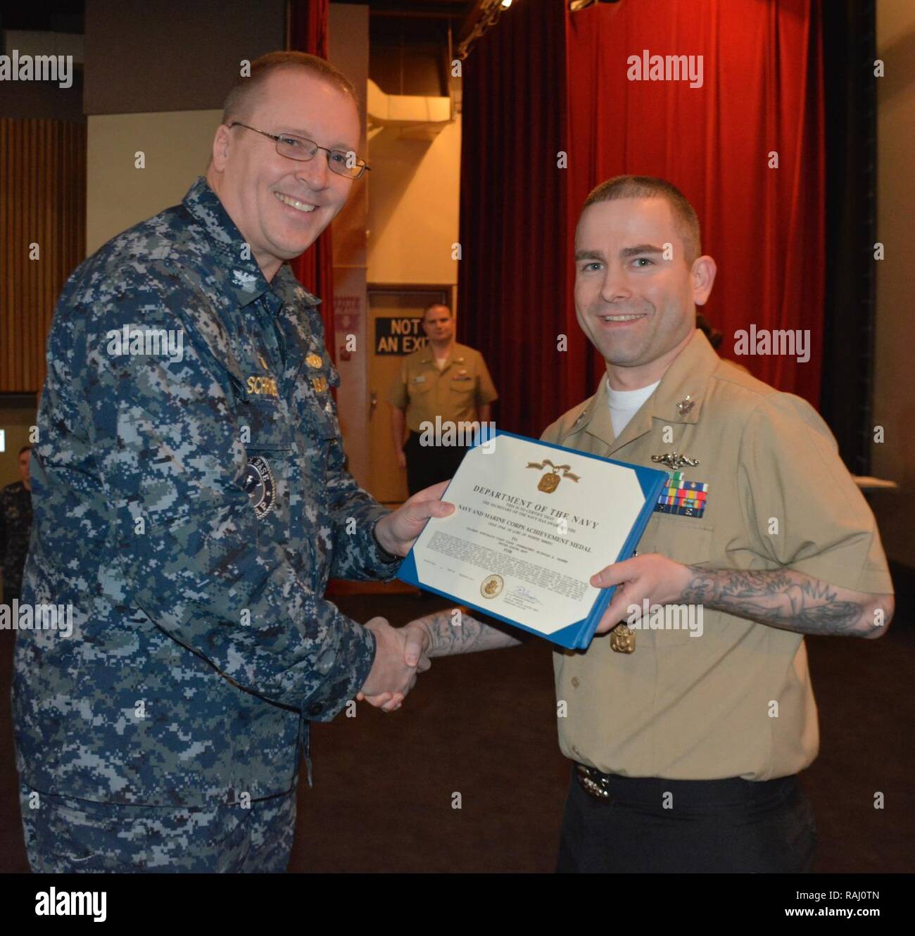 SILVERDALE, Wash. (Feb. 8, 2017) – Capt. Alan Schrader (left), Naval Base Kitsap (NBK) commanding officer, presents Culinary Specialist 1st Class Nicholas Gagner with the Navy and Marine Corps Achievement Medal during an all-hands call held at the NBK-Bangor Theater. More than 30 awards and decorations were bestowed to NBK personnel during the event. Stock Photo