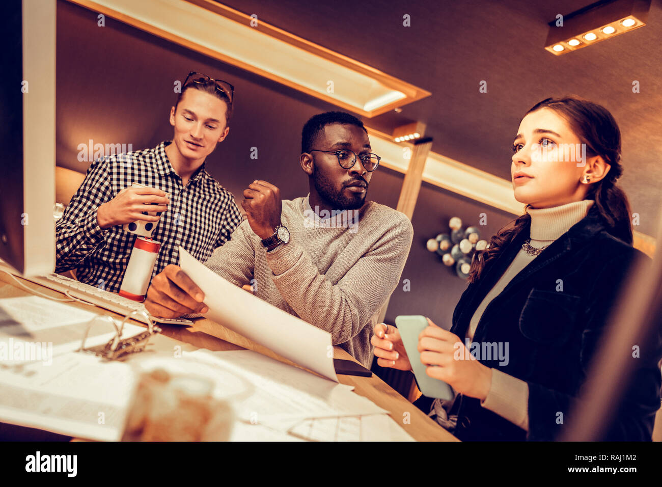 Worried brunette girl listening to her colleagues Stock Photo