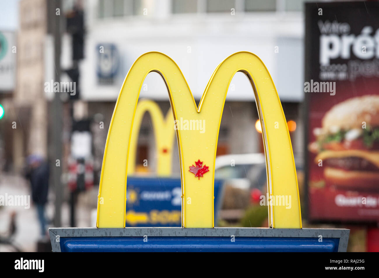 MONTREAL, CANADA - NOVEMBER 6, 2018: Mc Donald's Canada logo with its iconic M in front of a local restaurant, with the Iconic Canadian Maple Leaf in  Stock Photo
