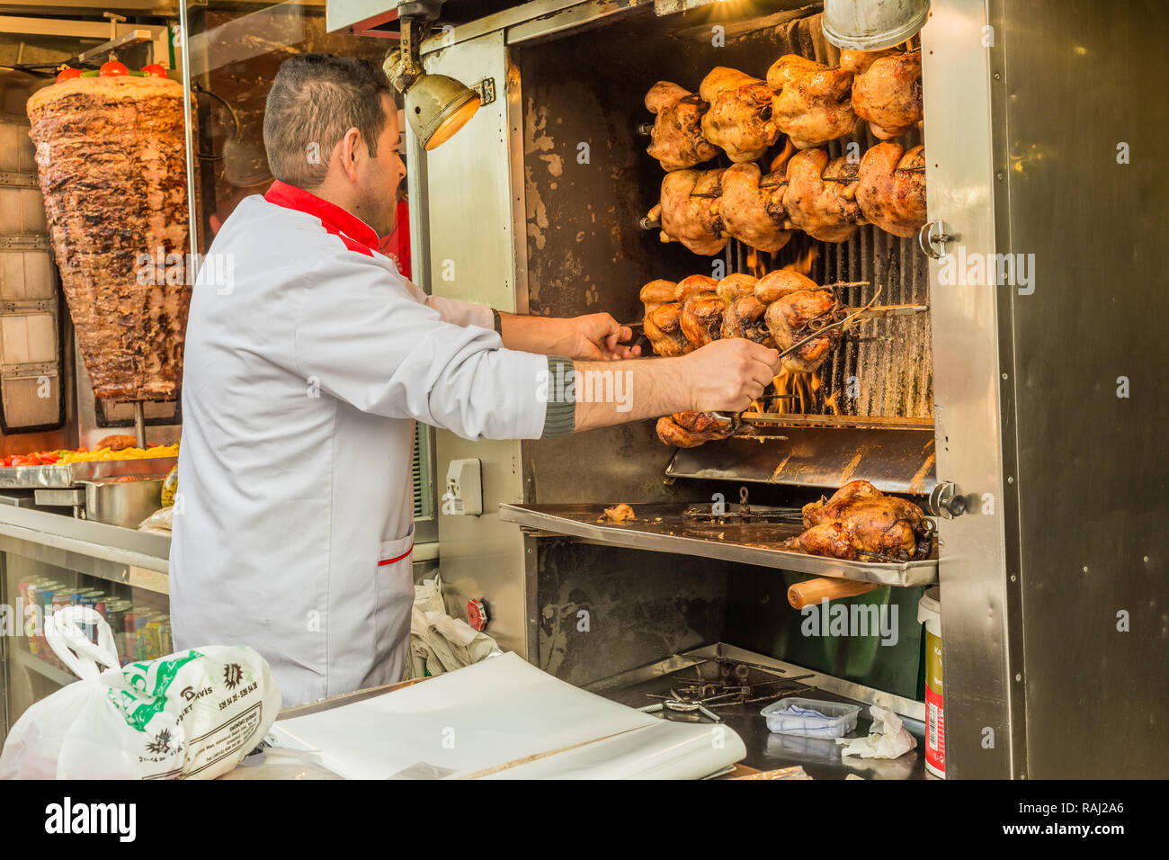 Istanbul, Turkey, February 24, 2015: Chef checking chickens roasting in a rotissarie machine. Stock Photo