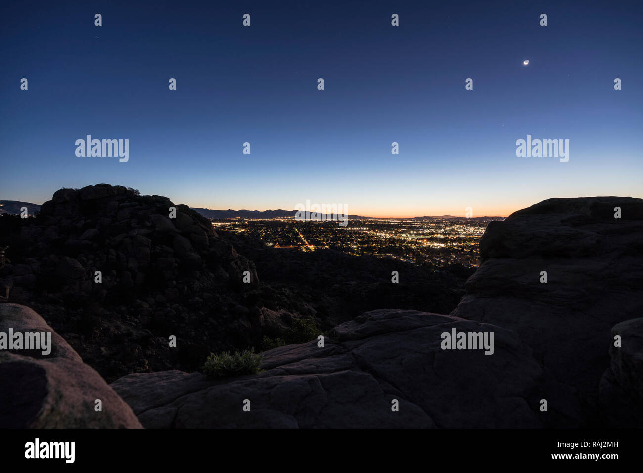 Predawn rocky mountaintop view of sprawling west San Fernando Valley neighborhoods in Los Angeles, California. Stock Photo