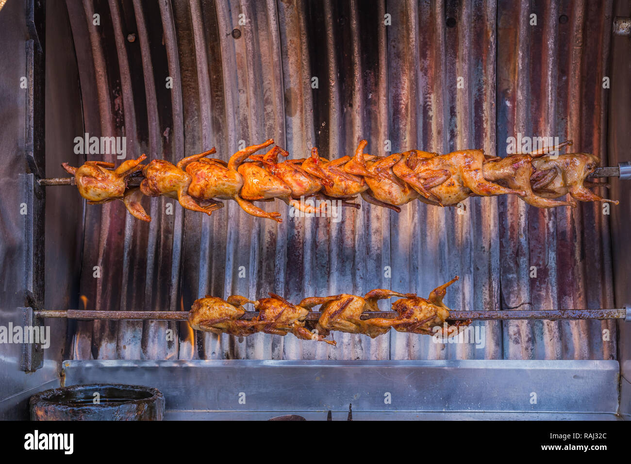 Small chickens roasting in a rotissarie machine, in Istanbul, Turkey. Stock Photo