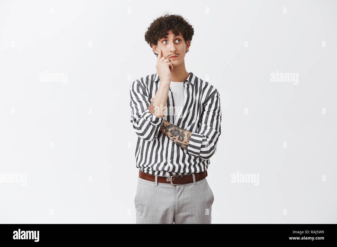 Curious Thoughtful And Cute Jewish Guy With Dark Curly Hair And Moustache Holding Hand On Face