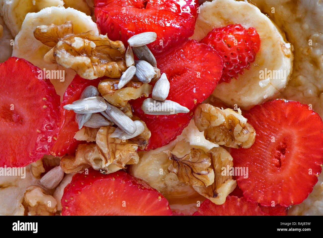 A healthy breakfast of fruits, nuts and seed like strawberries, pumpkin seeds, banana and walnuts Stock Photo