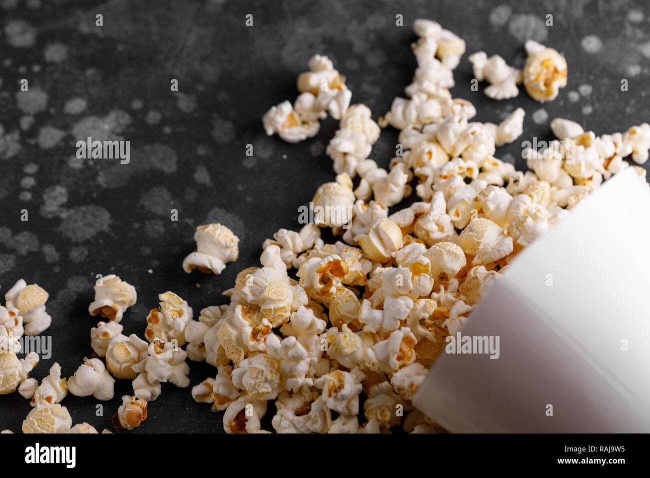 Snack for watching movies. Popcorn bucket upside down on a textural background. Close-up. Stock Photo