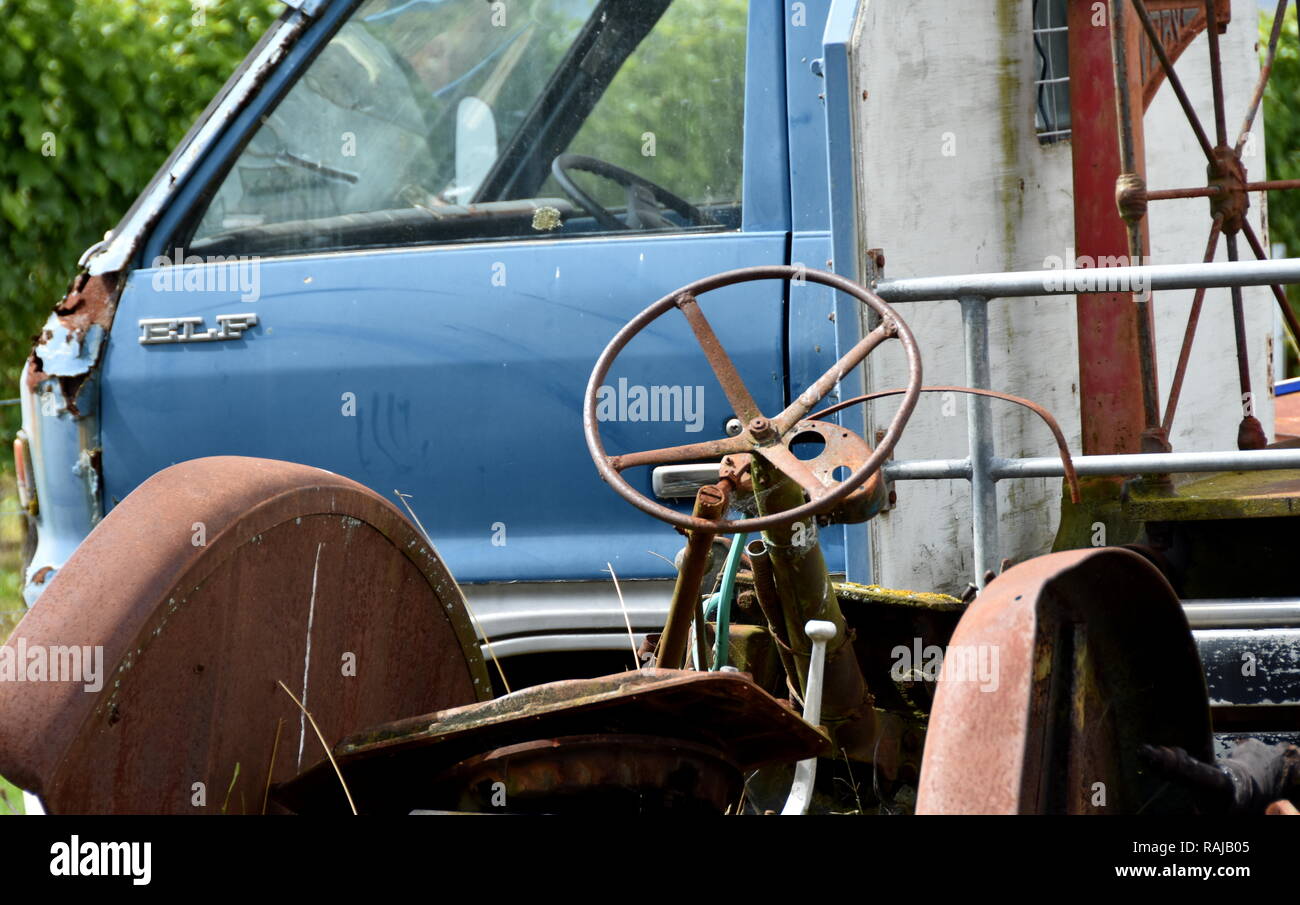 Van and tractor in a small wrecking yard next to a vineyard Stock Photo