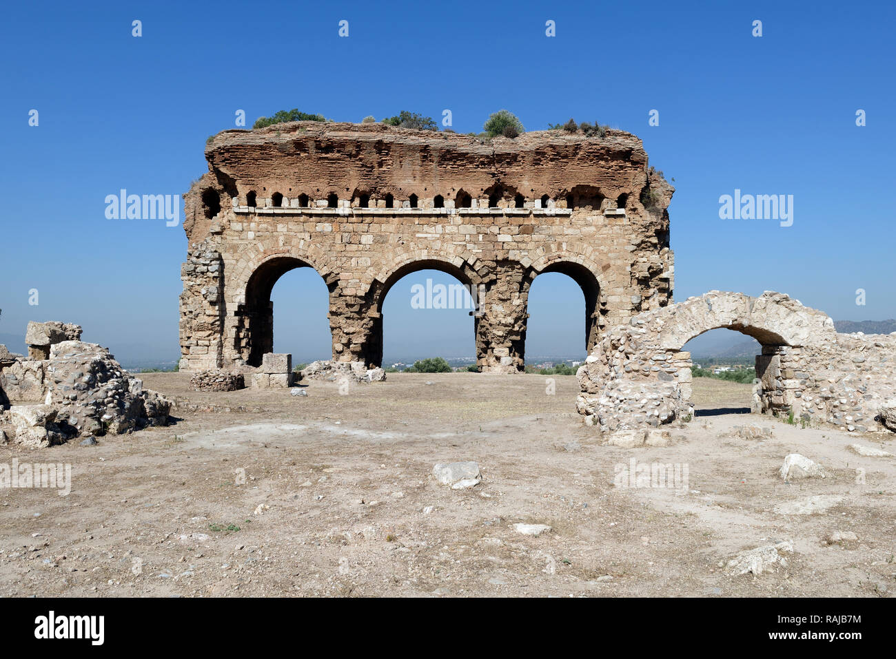 The imposing three arched structure that is part of the Bath-Gymnasium complex, ancient city of Tralleis, Aydin, Anatolia, Turkey. Dated to the 3rd ce Stock Photo