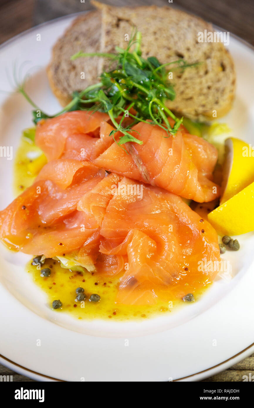 Smoked salmon served with wholegrain bread and wedges of lemon. The salmon is Scottish. Stock Photo