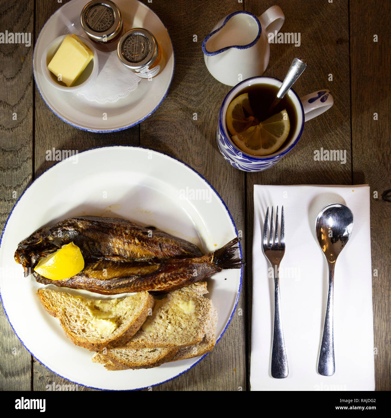 Craster kipper served with toast for breakfast in Northumberland, England. The Northumbrian delicacy is served with Earl Grey tea. Stock Photo