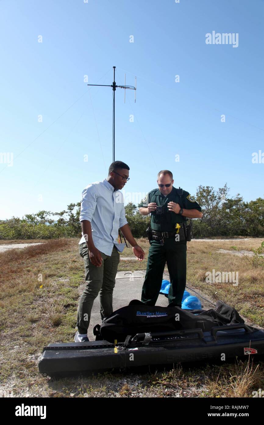A psychological operations Paratrooper explains components of a radio broadcast system to a Monroe County Sheriff’s Office Deputy, role-playing a Conch Republic police officer, Feb. 3, 2017. Local law enforcement of Monroe County, Florida, participated in Operation Warrior Anvil, a validation exercise held in Key West, Florida, by 7th Military Information Support Battalion, 4th Military Information Support Group. The exercise validated teams through unparalleled training with joint, inter-agency, and civic partners in real-world urban environments that reinforced PSYOP fundamentals, fostered t Stock Photo