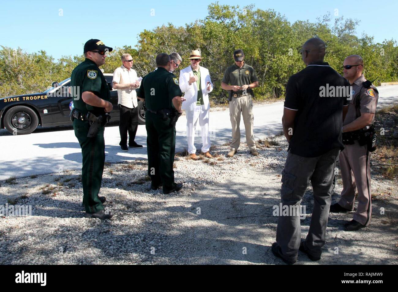 A psychological operations Paratrooper role-playing the embassy security officer, shown center in a white suit, negotiates for the release of the detained broadcast teams from Monroe County Sheriff’s Office Deputies, role-playing a Conch Republic police officer, Feb. 3, 2017. Local law enforcement of Monroe County, Florida, participated in Operation Warrior Anvil, a validation exercise held in Key West, Florida, by 7th Military Information Support Battalion, 4th Military Information Support Group. The exercise validated teams through unparalleled training with joint, inter-agency, and civic pa Stock Photo