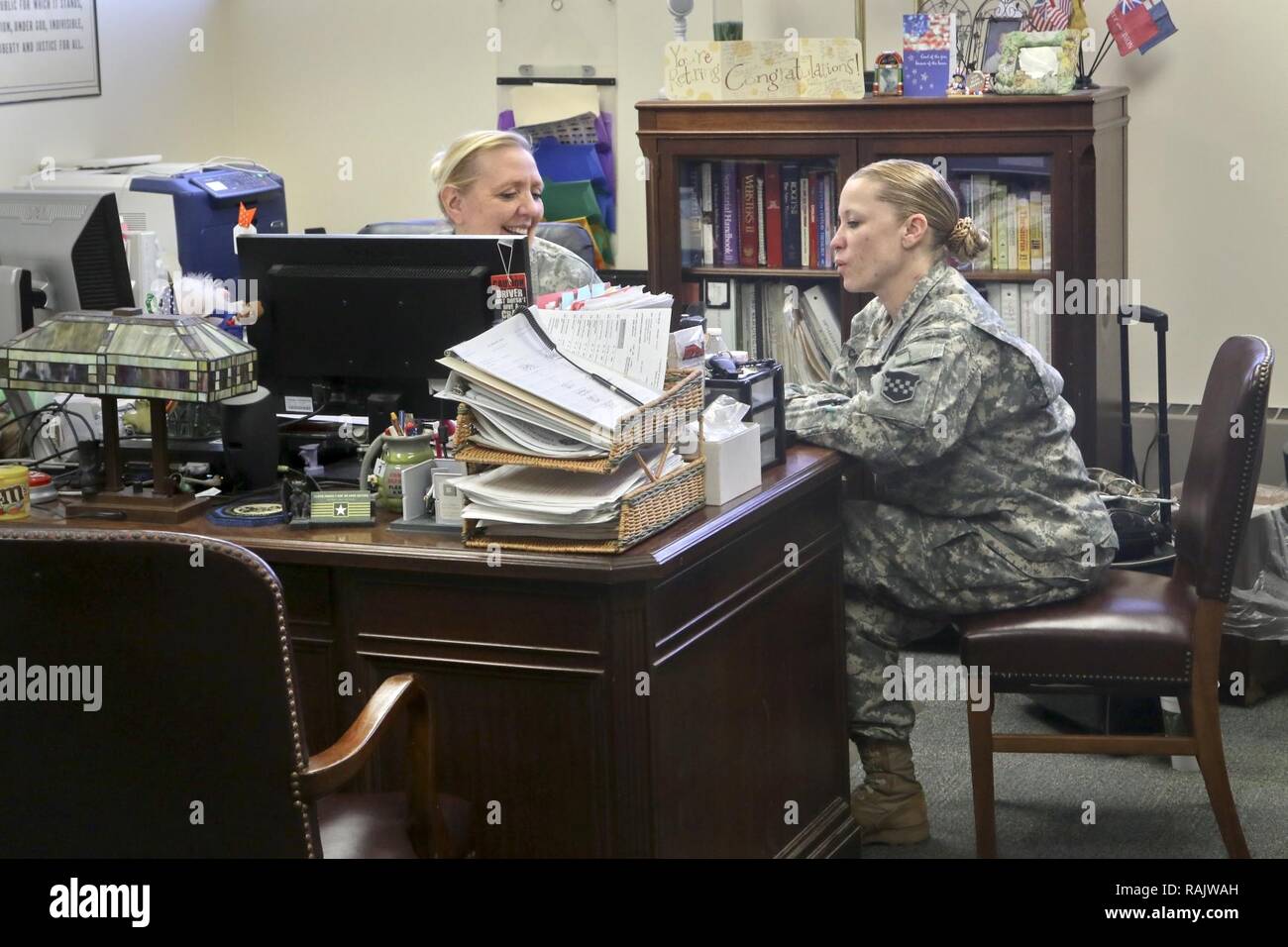 Army Sgt. 1st Class Deborah Hartman of the 318th Press Camp Headquarters speaks with Army Staff Sgt. Carrie Castillo during her last day as the unit administrator during the 318th battle assembly weekend, Forest Park, Ill., February 11, 2017. Stock Photo