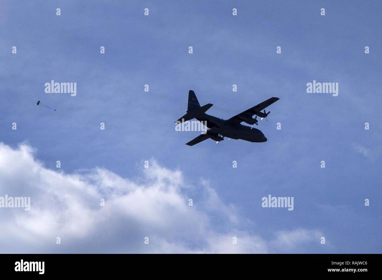 A C-130H Hercules with the 166th Airlift Wing, Delaware Air National Guard, performs an air drop at Coyle Drop Zone near Joint Base McGuire-Dix-Lakehurst, N.J., Feb. 10, 2017. The air drop was in support of drop zone safety officer training for tactical air control party Airmen with the 227th Air Support Operations Squadron, New Jersey Air National Guard and aerial traffic controllers with the 621st Contingency Response Group, Air Mobility Command. Drop zone safety officers are responsible for establishing and operating day and night drop zones for personnel/resupply missions flown by Air Forc Stock Photo