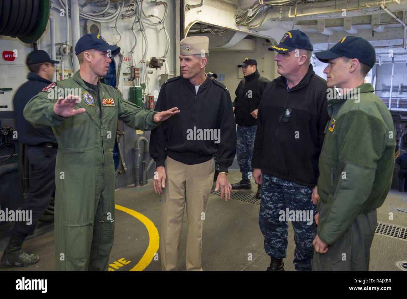 SASEBO, Japan(Feb. 14, 2017) Lt. Cmdr. John Kadz, mini boss of amphibious assault ship USS Bonhomme Richard (LHD 6), describes the multi-purpose capabilities of the hangar bay to Capt. David O. Bynum, chaplain, U.S. Pacific Fleet, during a ship tour. Bonhomme Richard, forward-deployed to Sasebo, Japan, is serving forward to provide a rapid-response capability in the event of a regional contingency or natural disaster. Stock Photo