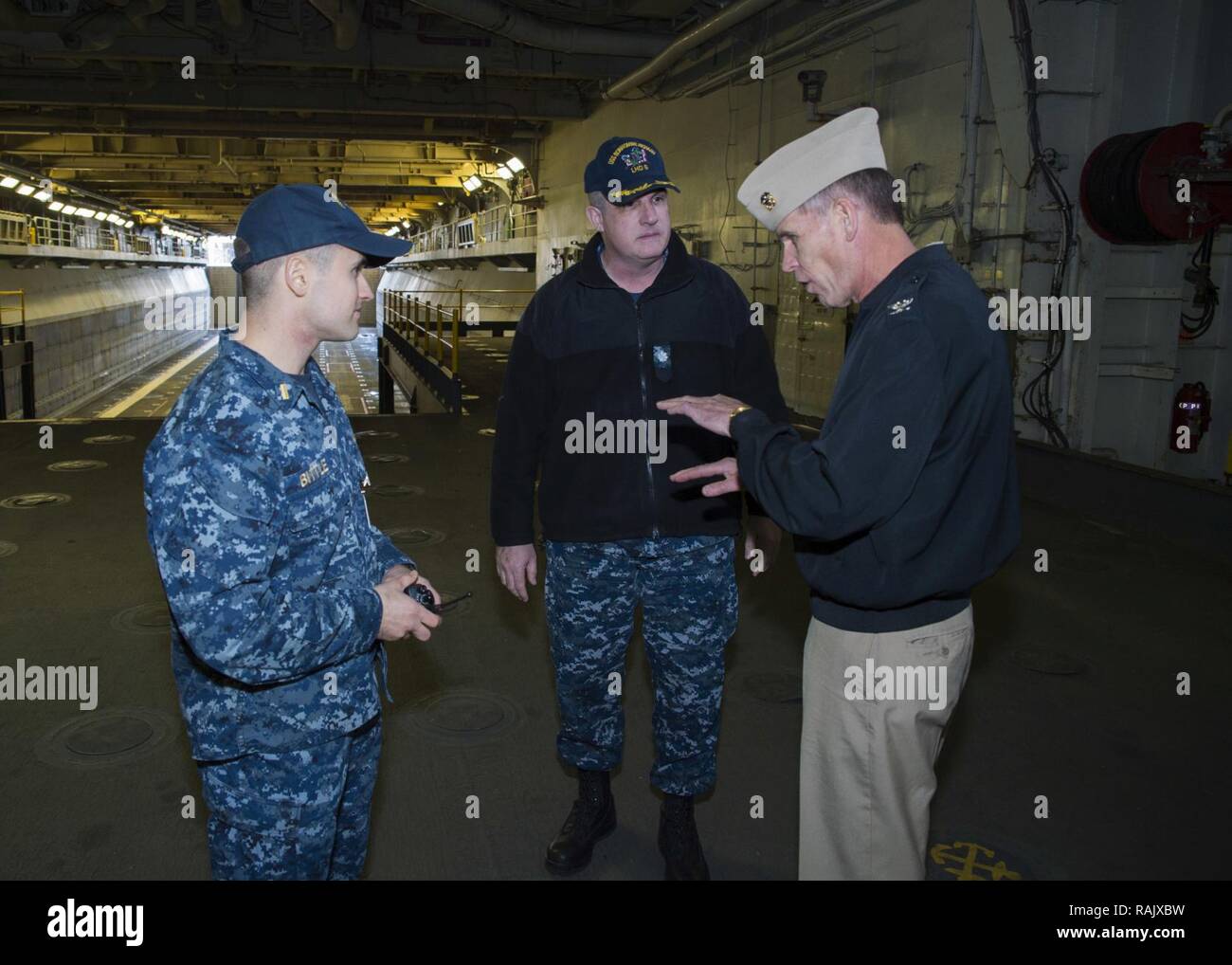 SASEBO, Japan(Feb. 14, 2017) Ensign Ben Bittle, a deck department division officer aboard amphibious assault ship USS Bonhomme Richard (LHD 6), describes Bonhomme Richard’s well deck capabilities to Capt. David O. Bynum, chaplain, U.S. Pacific Fleet, during a ship tour. Bonhomme Richard, forward-deployed to Sasebo, Japan, is serving forward to provide a rapid-response capability in the event of a regional contingency or natural disaster. Stock Photo