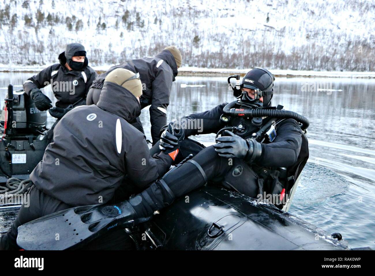 RAMSUND, Norway (Feb. 9, 2017) Lt. Benjamin Fernandez, center, company commander of Explosive Ordnance Disposal Mobile Unit (EODMU) 8 Mine Countermeasures (MCM) Company, conducts a cold water MCM neutralization dive. EODMU-8 is participating in Exercise Arctic Specialist 2017, a multi-national EOD exercise conducted in the austere environments of northern Norway. Stock Photo