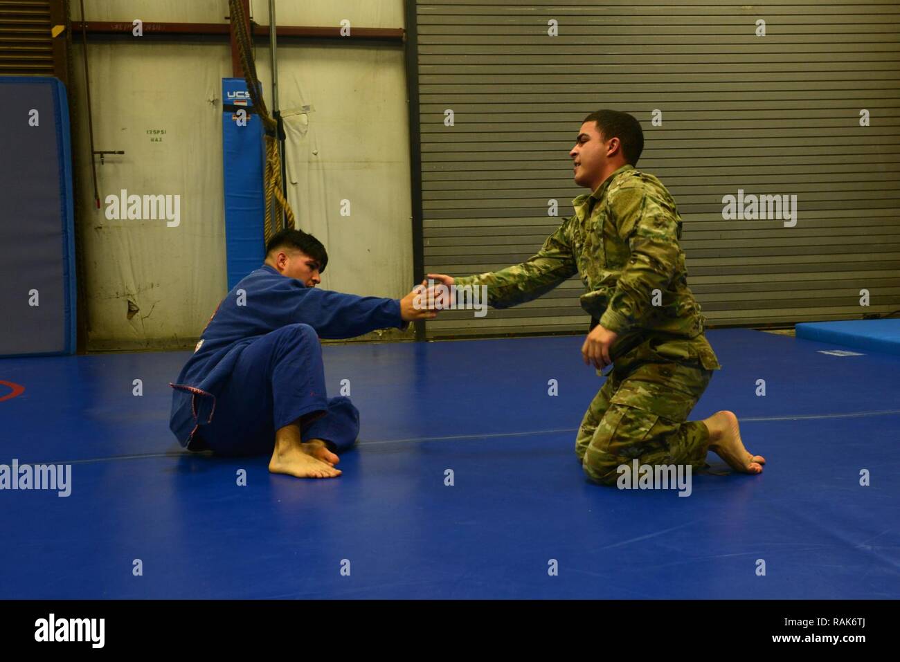 U.S. Army Staff Sgt. Joel Lung, U.S. Army Central battalion intelligence noncommissioned officer in charge, and Pfc. Melvyn Santos, U.S. ARCENT geospatial engineer, congratulate each other after a sparring match at Shaw Air Force Base, S.C., Feb. 7, 2017. Both Airmen and Soldiers can attend classes, including U.S. ARCENT combatives, at the Combative House. Stock Photo