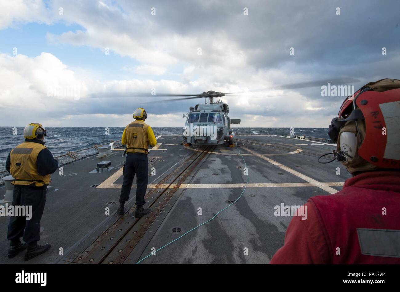SEA OF JAPAN (Feb. 10, 2017) Sailors assigned to the forward-deployed Arleigh Burke-class guided-missile destroyer USS McCampbell (DDG 85) conduct flight deck operations with an MH-60R Sea Hawk helicopter attached to the “Warlords” of the Helicopter Maritime Strike Squadron (HSM) 51. McCampbell is on patrol in the U.S. 7th Fleet area of operations in support of security and stability in the Indo-Asia-Pacific region. Stock Photo