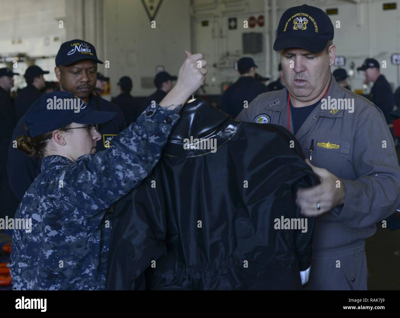 SAN DIEGO (Feb. 13, 2017) - Chief Warrant Officer 4 Richard Barr, a member of the Board of Inspection and Survey (INSURV) team, inspects a search and rescue wetsuit during a demonstration on board the aircraft carrier USS Nimitz (CVN 68). Nimitz is currently undergoing INSURV in preparation for an upcoming 2017 deployment. Stock Photo