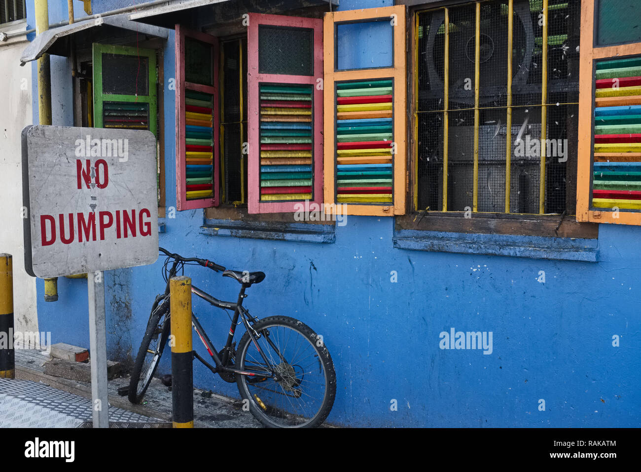 A 'No Dumping' sign in front of a colorful house in Little India, Singapore, an area more prone to littering than others Stock Photo