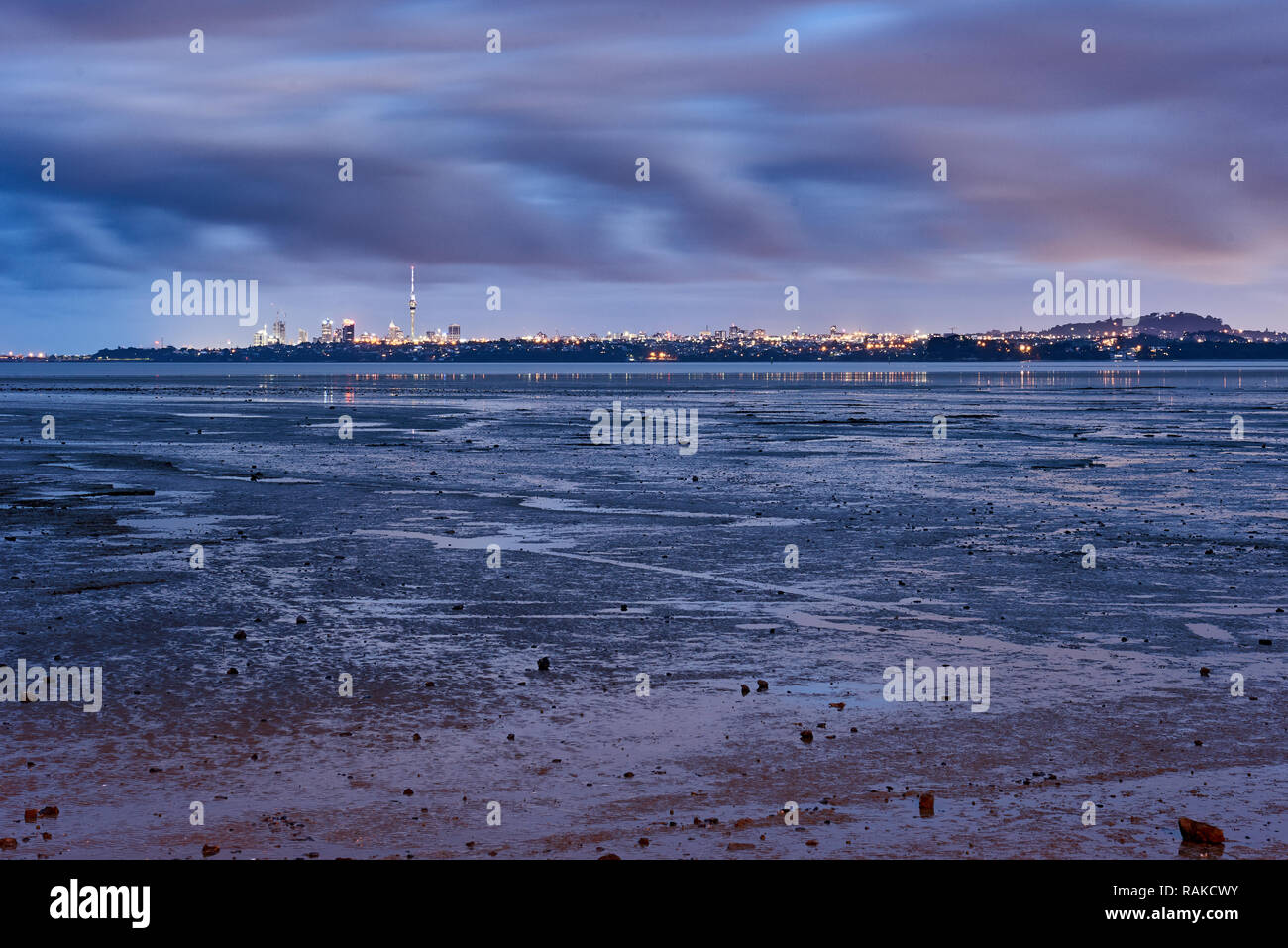 View across the bay from Te Atatu peninsula towards Auckland city on a cloudy day at low tide Stock Photo