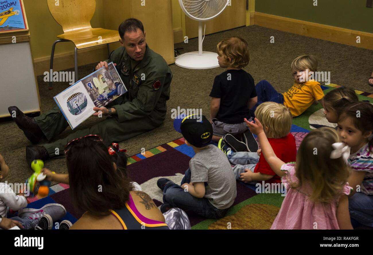 U.S. Marine Corps Maj. Benjamin D. Apple, the operations officer for Marine Fighter Training Squadron 401 (VMFT-401), stationed out of Marine Corps Air Station Yuma, Ariz., reads "Violet Pilot," an aviation-themed children's book to families at the main Yuma County Library, Wednesday, Feb. 15, 2017. Stock Photo