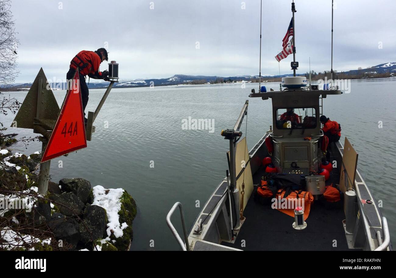 Petty Officer 3rd Class Robert Demasi, a machinery technician at Aids to Navigation Team Astoria, services Hunts Mill Point Light 44A while underway in the lower Columbia River, Feb. 7, 2017.    The ANT received the aid discrepency from a passing mariner and then sent out a team to fix the aid and other short range ATON on the lower Columbia River.    U.S. Coast Guard Stock Photo