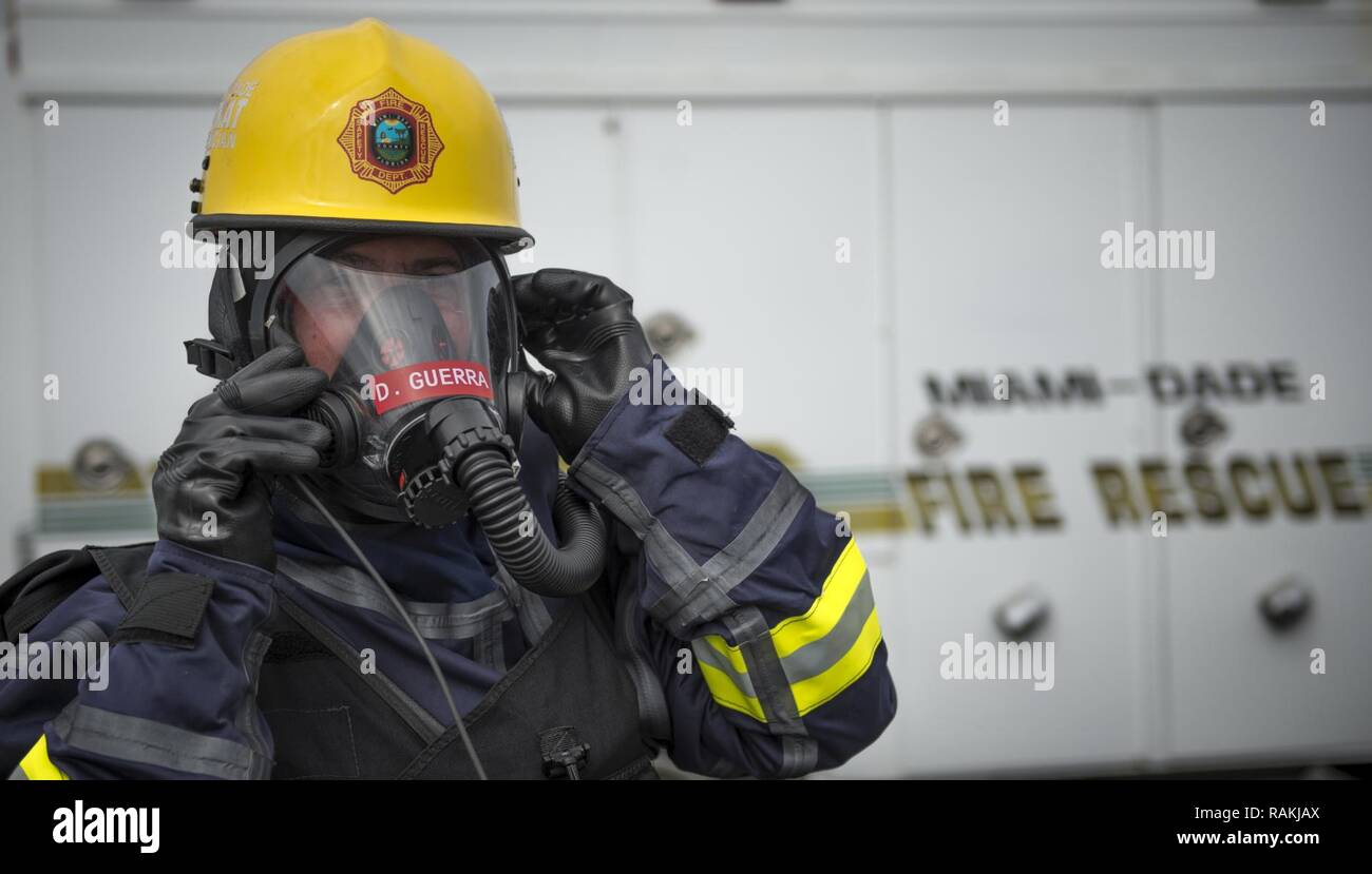 David Guerra, Miami-Dade Fire Rescue air rescue flight medic, adjusts protective equipment during a hazardous material decontamination exercise on the Port of Miami, Fla. Feb 18, 2017.The exercise was led by Miami-Dade Fire Rescue and U.S. Army North under the supervision of U.S. Northern Command and provided soldiers and first responders the unique experience of operating together in a major metropolitan city. Stock Photo