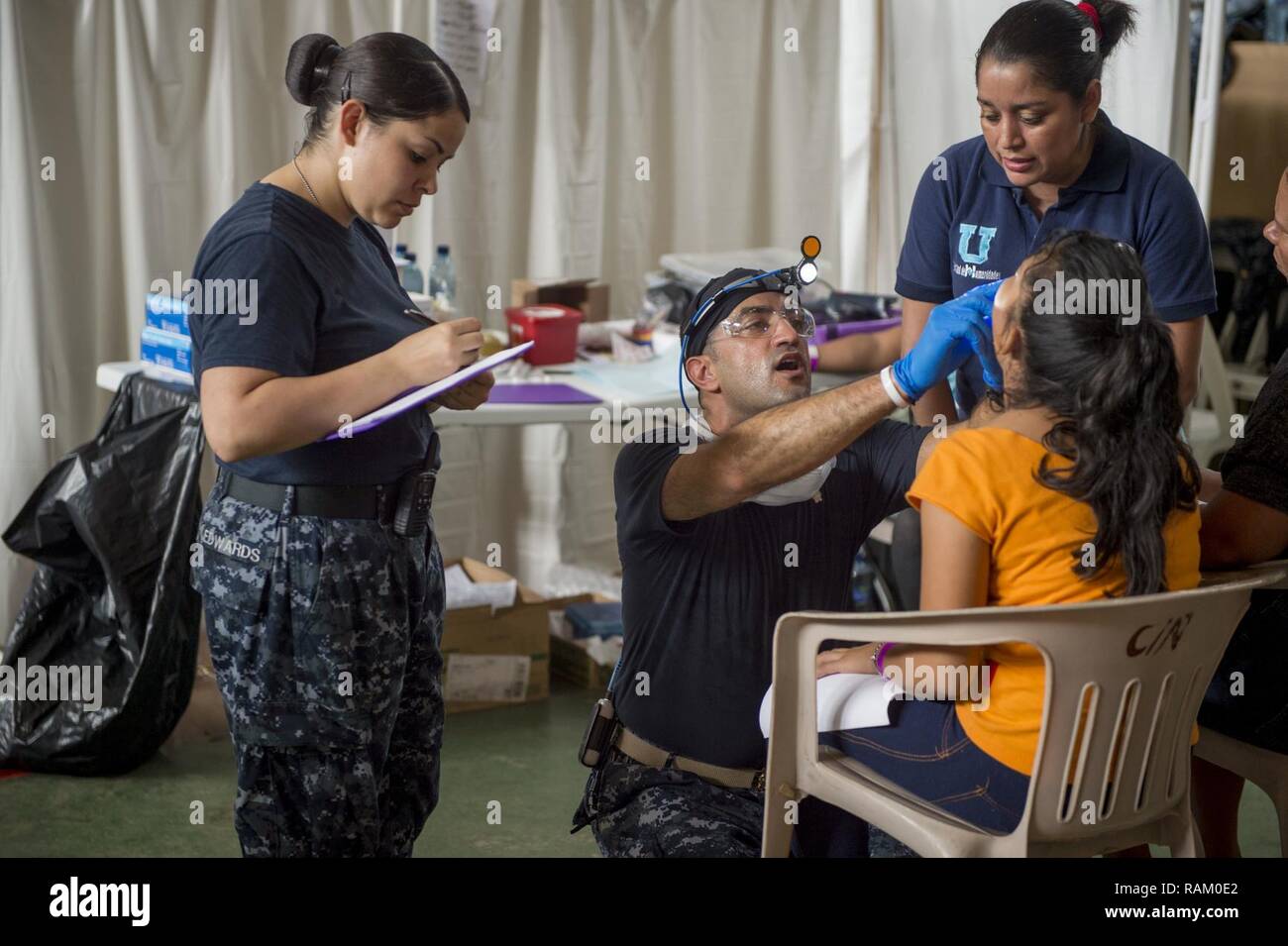 PUERTO BARRIOS, Guatemala (Feb. 10, 2017) - Lt. Farid Hamidzadeh, a native of Fort Lauderdale, Fla., attached to Naval Hospital Jacksonville, Fla., performs an oral exam while Hospital Corpsman 2nd Class Justine Edwards, a native of Albuquerque, N.M., assigned to Naval Medical Center Portsmouth, Va., logs the exam's findings at the Continuing Promise 2017 (CP-17) medical site in support of CP-17's visit to Puerto Barrios, Guatemala. CP-17 is a U.S. Southern Command-sponsored and U.S. Naval Forces Southern Command/U.S. 4th Fleet-conducted deployment to conduct civil-military operations includin Stock Photo