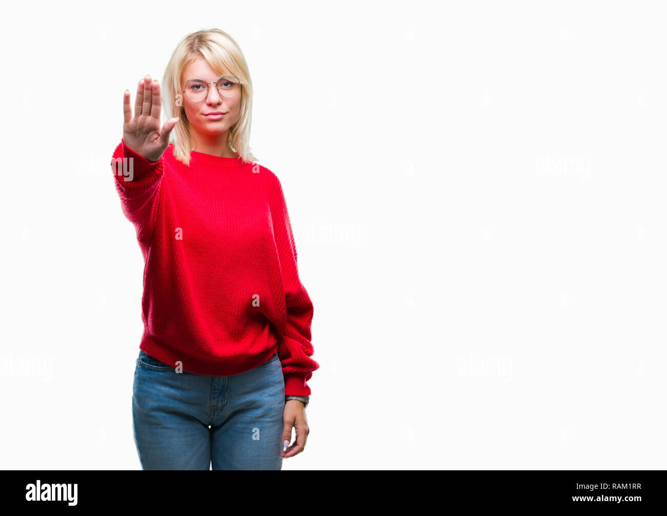 Young beautiful blonde woman wearing sweater and glasses over isolated background doing stop sing with palm of the hand. Warning expression with negat Stock Photo