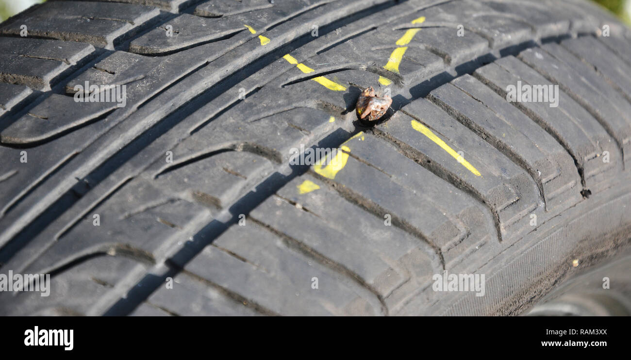 Fix flat car tire.  Car tire damage with nail. Stock Photo