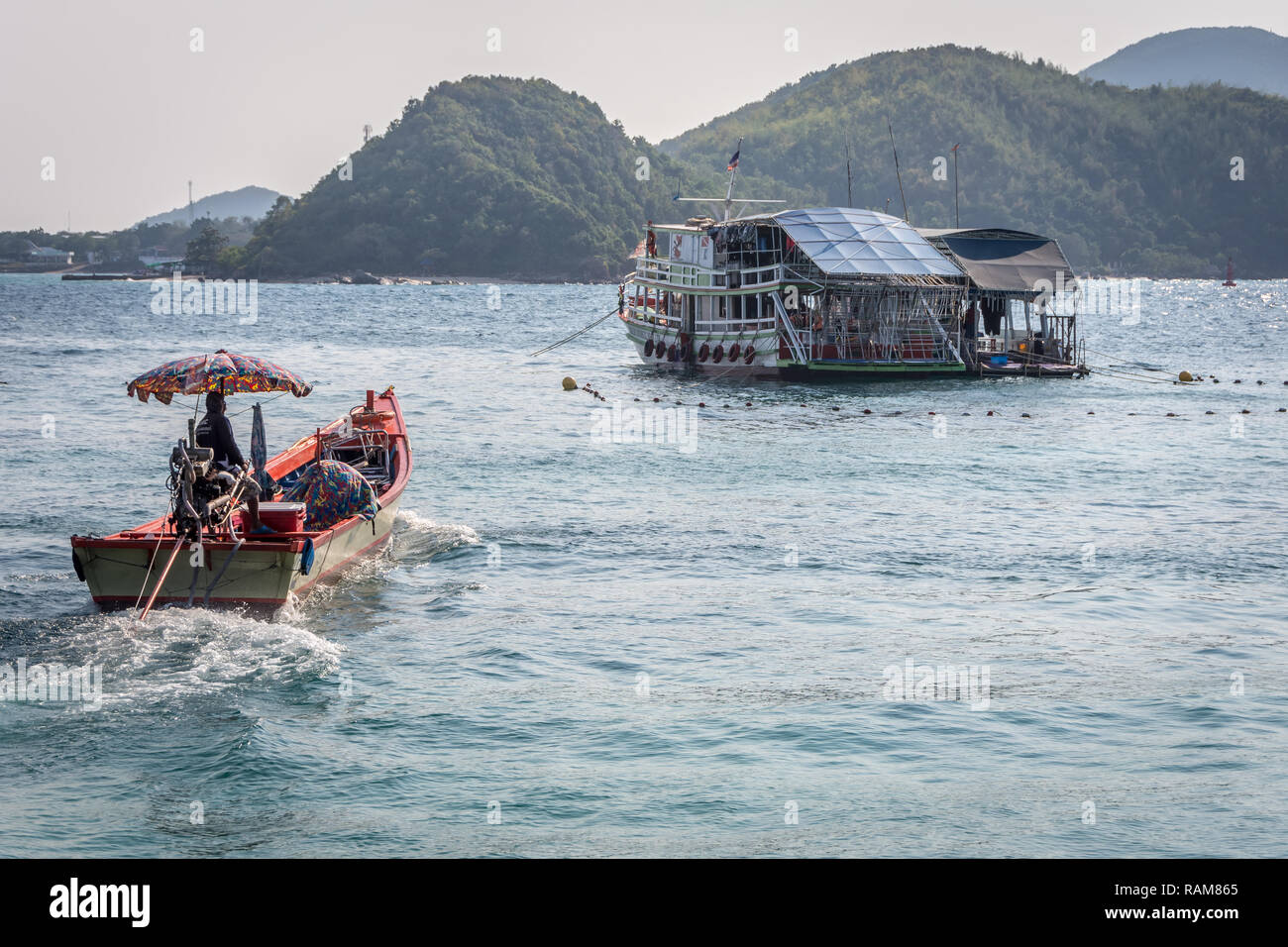 Colorful boats carry tourists from Pattaya city to islands nearby Stock Photo