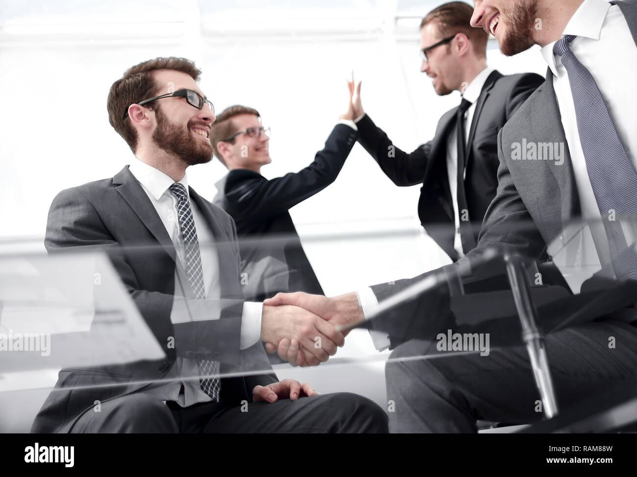 business handshake and business team giving each other high five Stock ...
