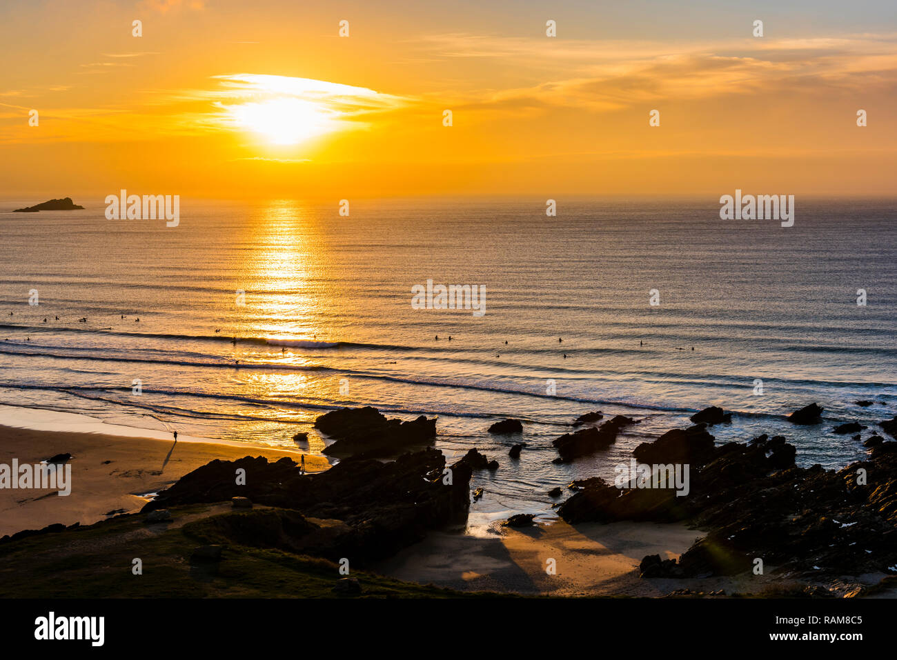 Surfers at sunset on Fistral Beach, Newquay, Cornwall, UK Stock Photo
