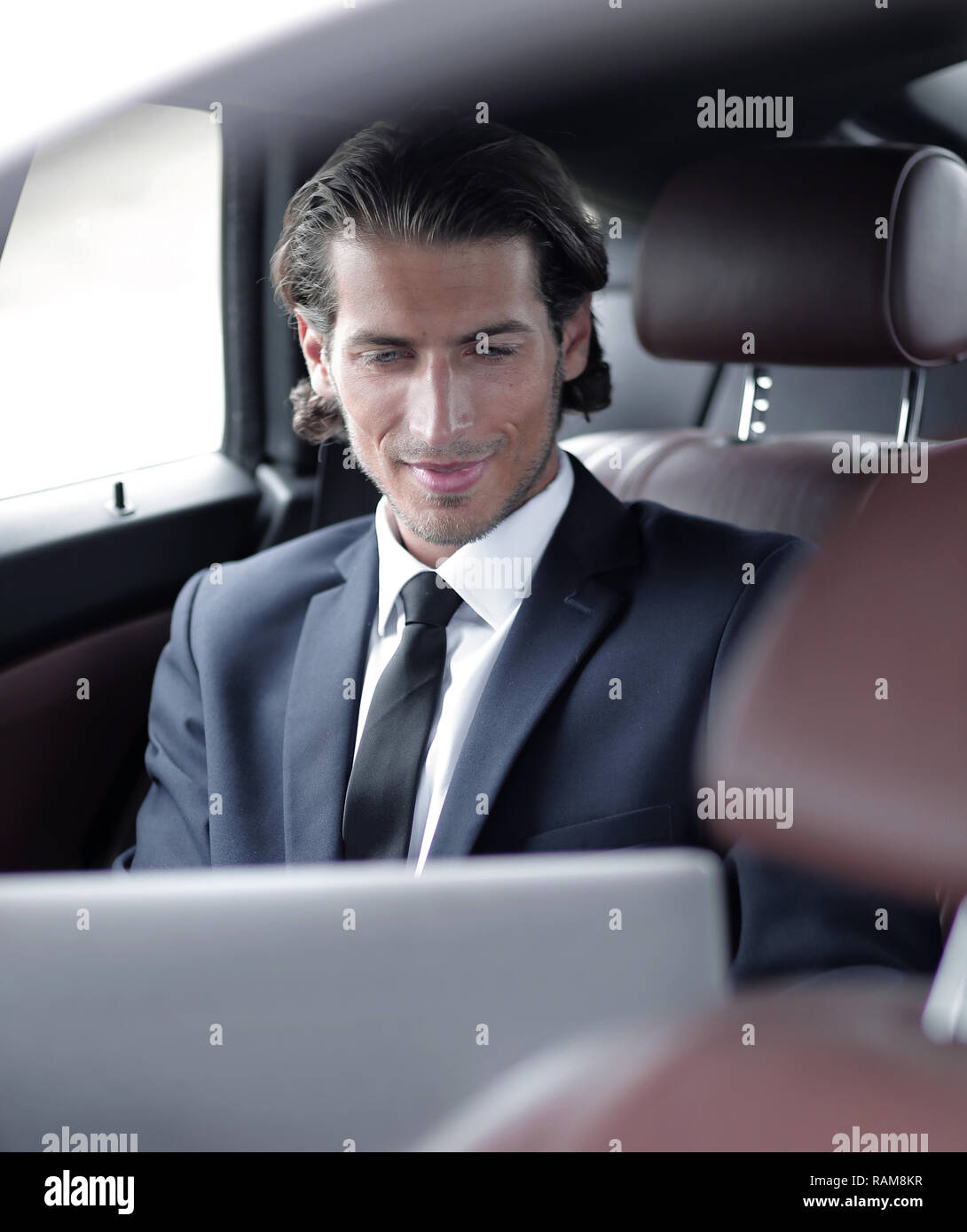 man working on laptop while sitting in the car Stock Photo