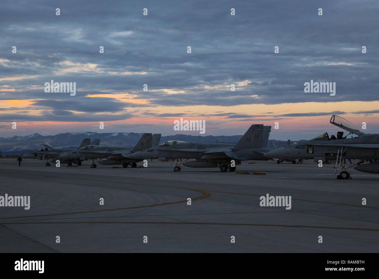 Several F/A-18C Hornets with Marine Fighter Attack Squadron (VMFA) 323 “Death Rattlers” rest on the flight line prior to night operations at Naval Air Station Fallon, Nev., Feb. 15. The Death Rattlers, one of two Marine Hornet squadrons to deploy aboard Navy aircraft carriers, trained at NAS Fallon to strengthen tactical air integration, fulfill predeployment requirements and build rapport with the Navy squadrons they will deploy with in summer 2017. Stock Photo