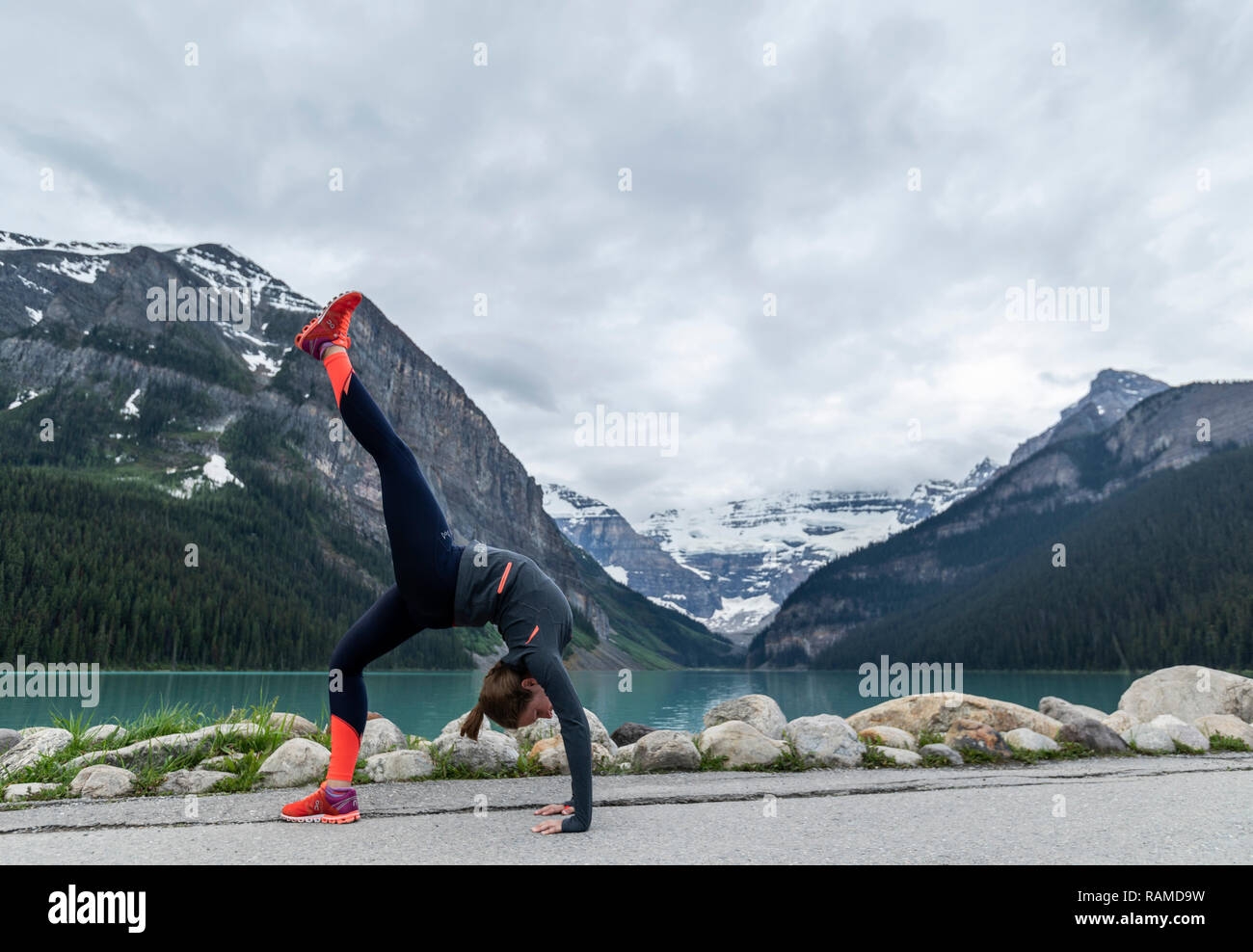 Girl doing a cartwheel with icy mountains in the back drop Stock Photo