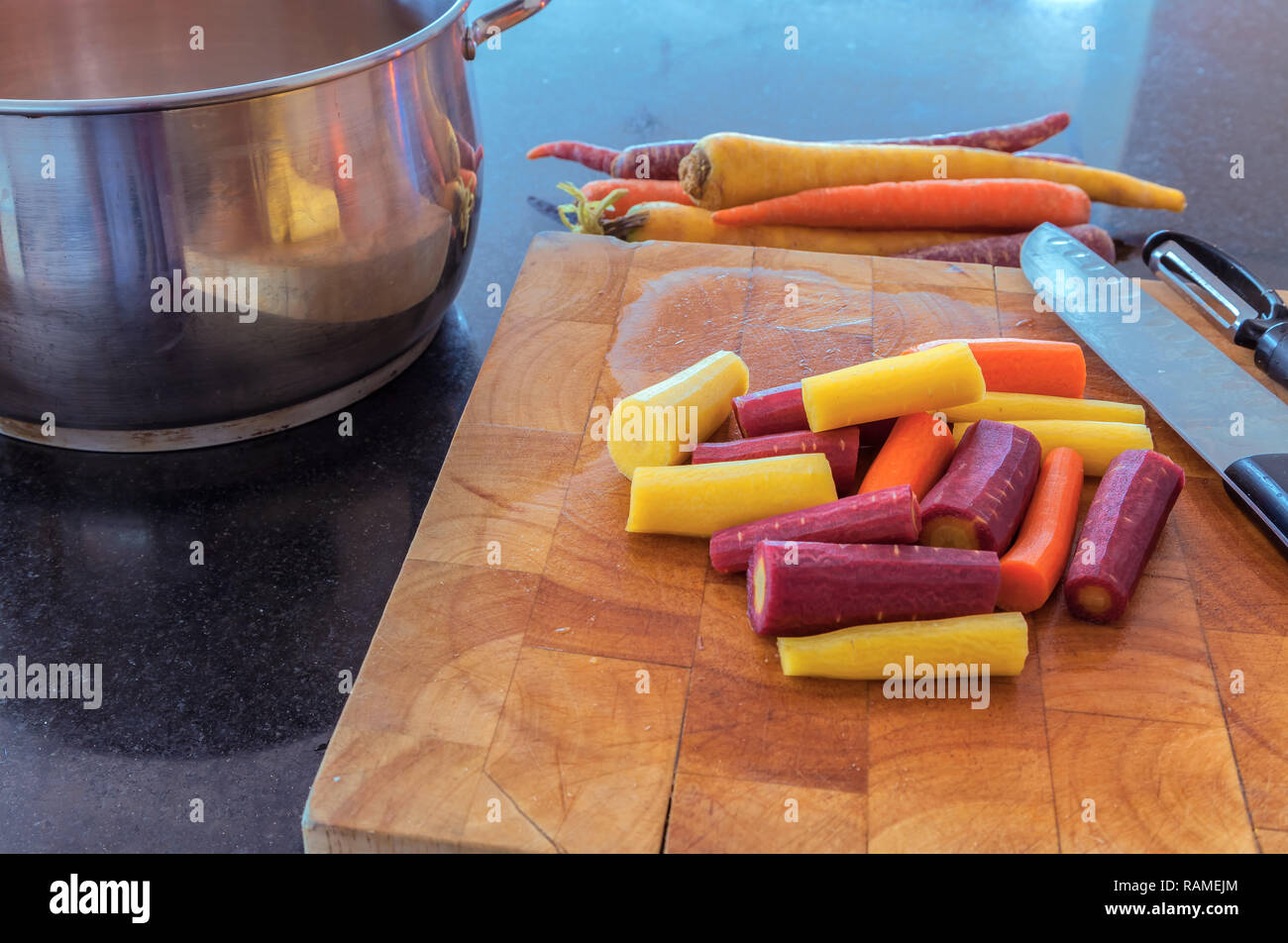 Chopped rainbow carrots on cutting board. Stock Photo