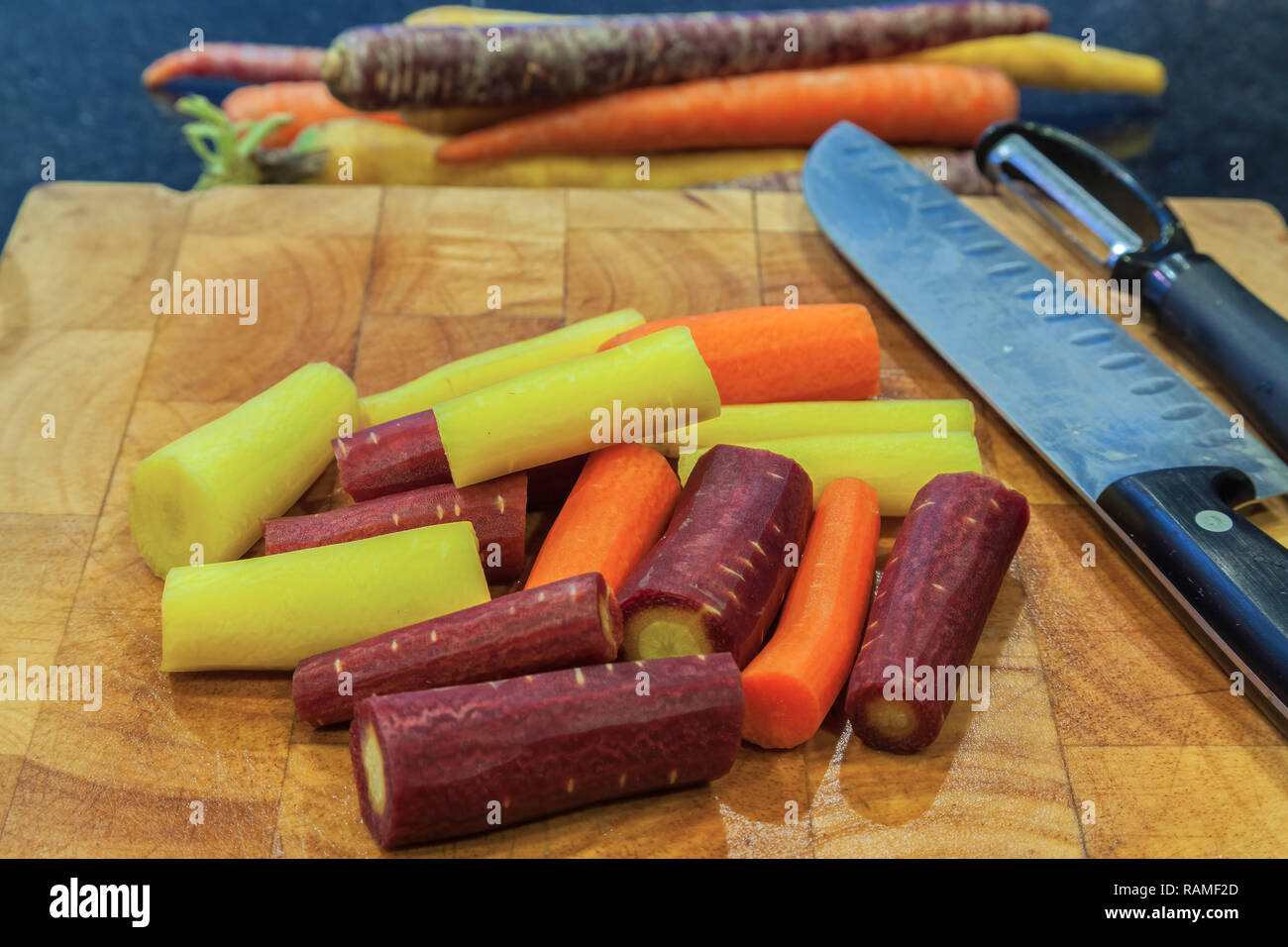Chopped rainbow carrots on cutting board. Stock Photo