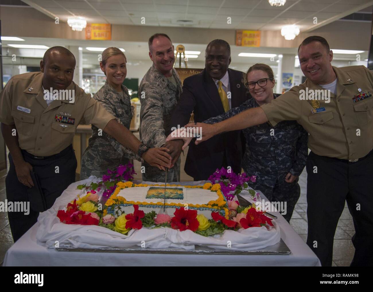 PEARL HARBOR (22 Feb. 2017) Col. Renzy Smith, deputy commander of Joint Base Pearl Harbor-Hickam, and guest speaker Alphonso Braggs, President of National Associations for the Advancement of Colored People Oahu chapter, alongside members of JBPHH’s Joint Forces Multicultural Committee, cut a cake after an African American History Month observation at Hickam’s Hale Aina dining facility.  The theme of this year’s event was “Success Always Leaves a Footprint” and the observation focused on key figures in African American history who made lasting contributions towards equal opportunities for Afric Stock Photo