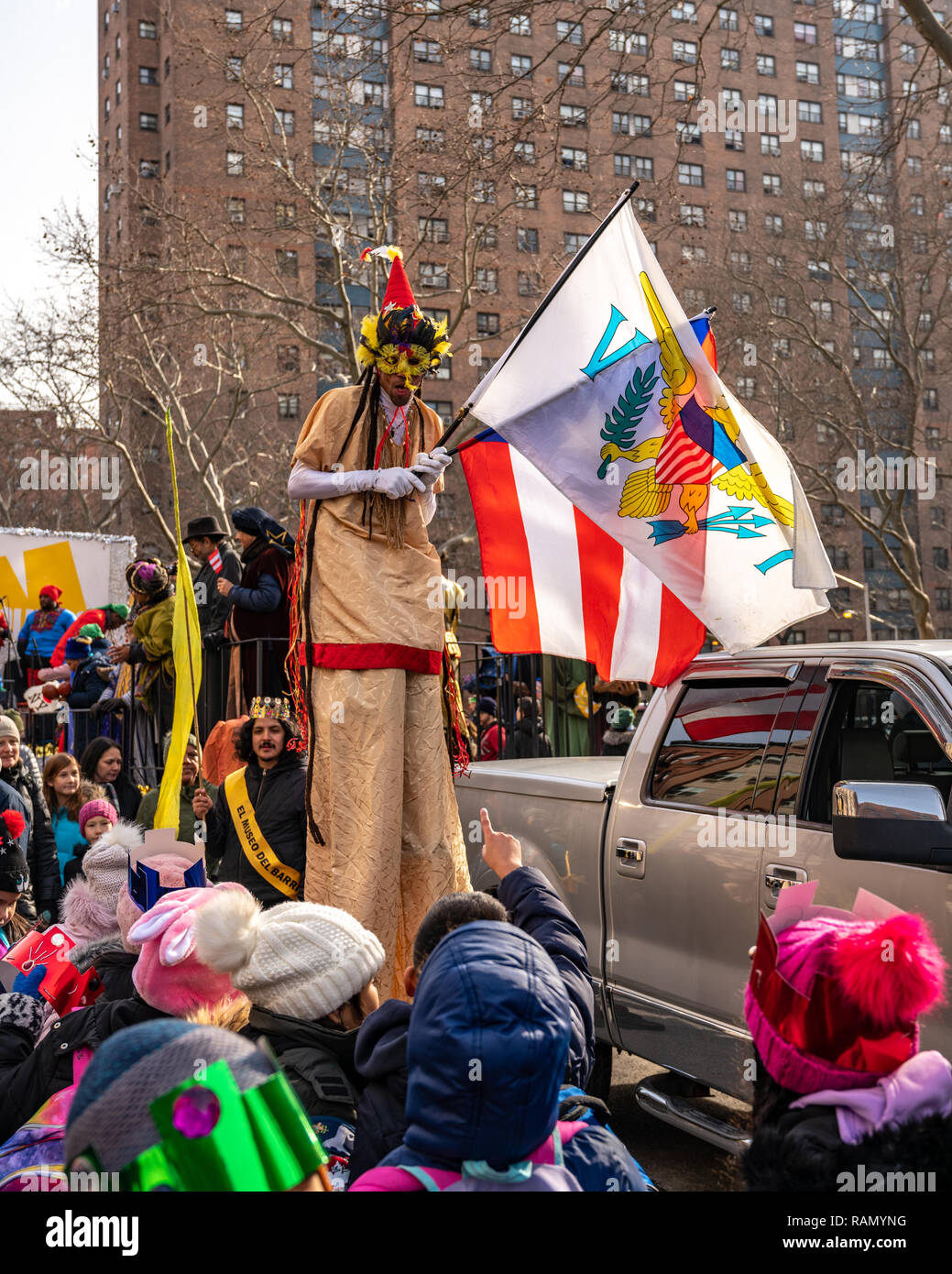 New York, USA. 4th Jan 2019. A performer on stilts entertains children during the 42nd Annual Three Kings Day Parade at El Barrio (East Harlem, New York city), Organized by El Museo del Barrio, the event celebrates the popular belief that three wise men visited Jesus. Credit: Enrique Shore/Alamy Live News Stock Photo