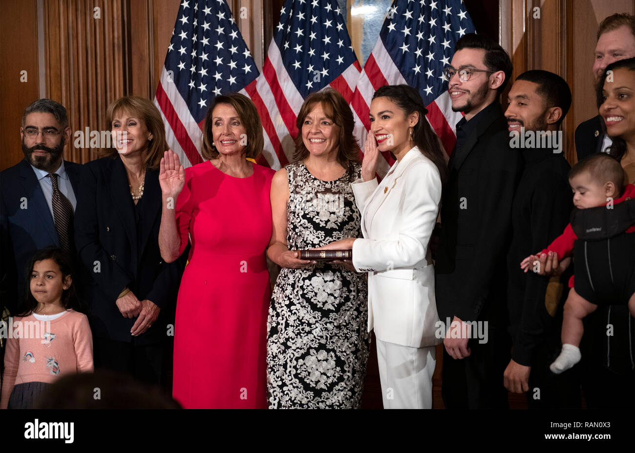Washington, United States Of America. 03rd Jan, 2019. United States Representative Alexandria Ocasio-Cortez (Democrat of New York) poses for a mock swearing-in photo with Speaker of the US House of Representatives Nancy Pelosi (Democrat of California) and members of her family as the 116th Congress convenes for its opening session in the US Capitol in Washington, DC on Thursday, January 3, 2019. Credit: Ron Sachs/CNP (RESTRICTION: NO New York or New Jersey Newspapers or newspapers within a 75 mile radius of New York City) | usage worldwide Credit: dpa/Alamy Live News Stock Photo