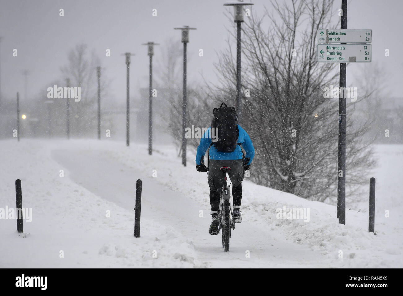 Munich Riem, Deutschland. 05th Jan, 2019. Wetterfeature-Fahrradkurier, Fahrradfahrer with backpack defies the snowdrifts and windbows on a snow-covered path in the Riemer Park.Radfahren in the snow Continuing snowfall on 05.01.2019, ensure snow chaos, traffic chaos, winter in Bavaria. | usage worldwide Credit: dpa/Alamy Live News Credit: dpa picture alliance/Alamy Live News Stock Photo