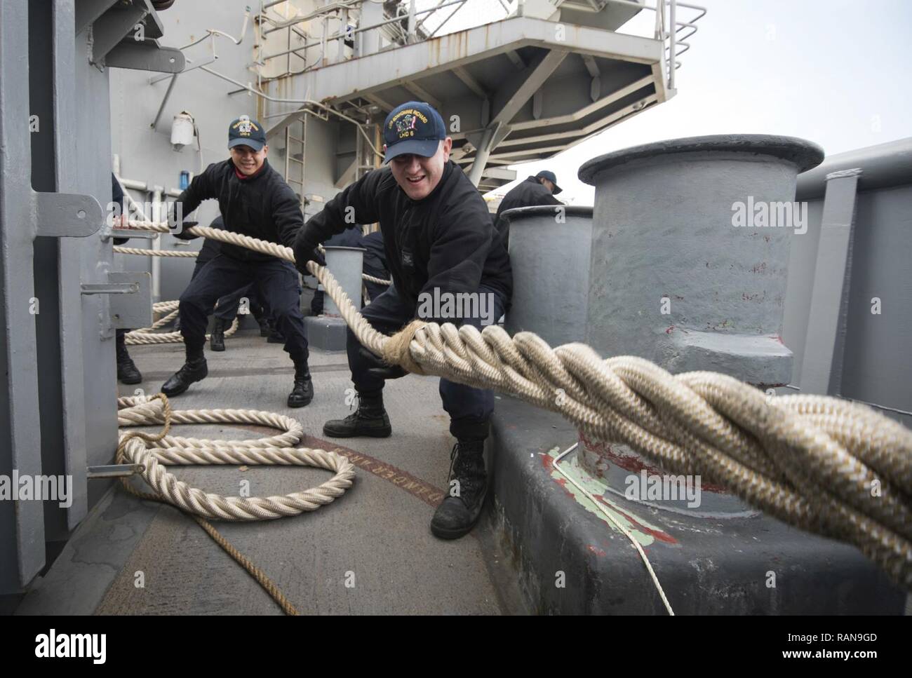 SASEBO, Japan (Feb. 27, 2017) Boatswain's Mate 2nd Class Jose Garcia  (center), from Chicago, and Aviation Ordnanceman Airman Steve Sarsaba, from  Waukegan, Ill., heave a mooring line on the fantail of amphibious