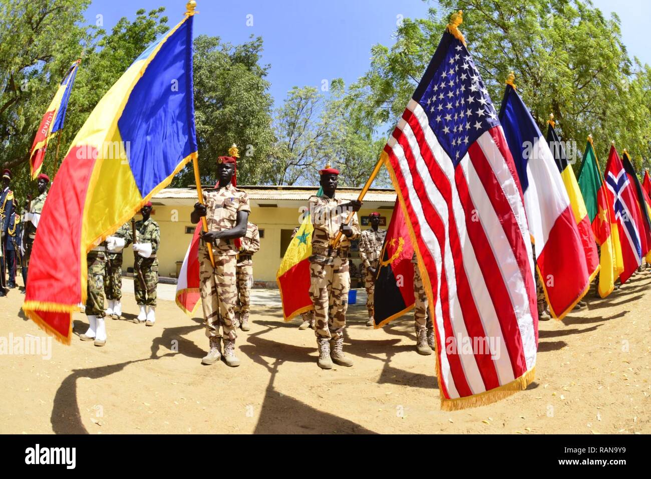 Soldiers of the Chadian Army raise the flags of partner nations participating in Flintlock 17 during the opening ceremony Feb. 27, 2017. Flintlock is an annual special operations exercise involving more than 20 nation forces that strengthens security institutions, promotes multilateral sharing of information, and develops interoperability among partner nations in North West Africa. Stock Photo