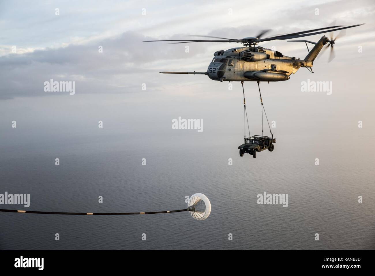 A CH-53 Super Stallion assigned to Marine Heavy Helicopter Squadron (HMH) 464, carries a Humvee during an aerial refueling training operation with Marine Aerial Refueler Transport Squadron (VMGR) 234 on Feb. 23, 2017. VMGR-234 assisted HMH-464 in the training to maintain interoperability. Stock Photo
