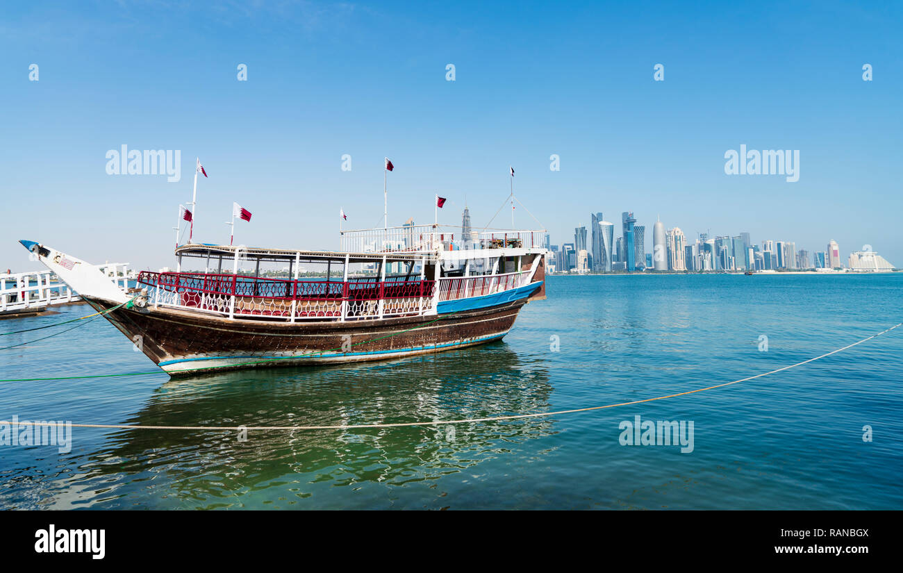 Traditional dhow passenger ferry and view of West Bay business district from The Corniche in Doha, Qatar Stock Photo