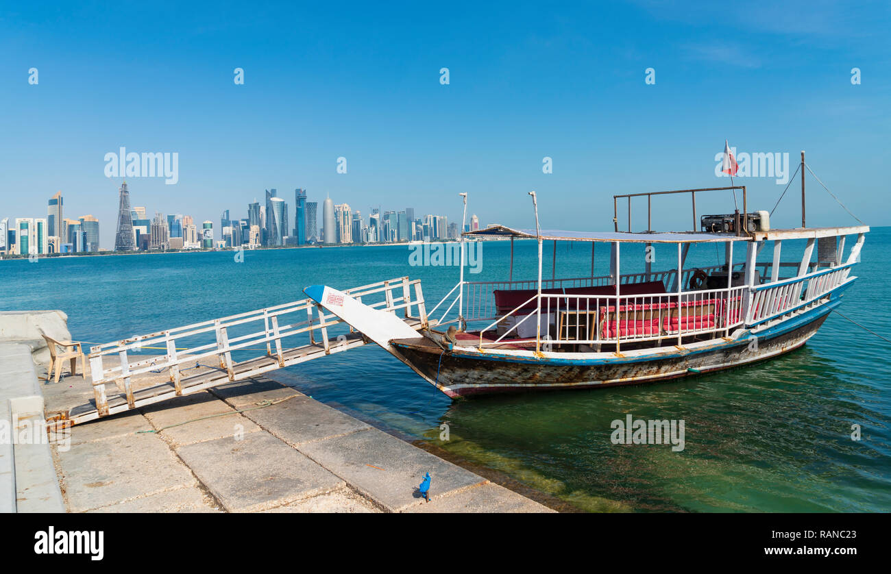 Traditional dhow passenger ferry and view of West Bay business district from The Corniche in Doha, Qatar Stock Photo