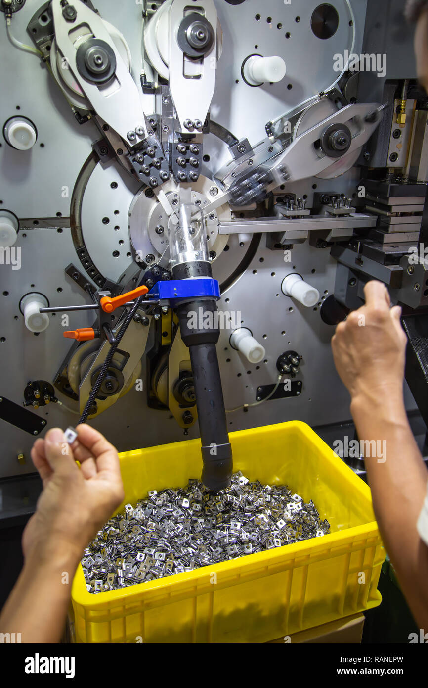 Worker checking quality of square plate washers from square plate ...