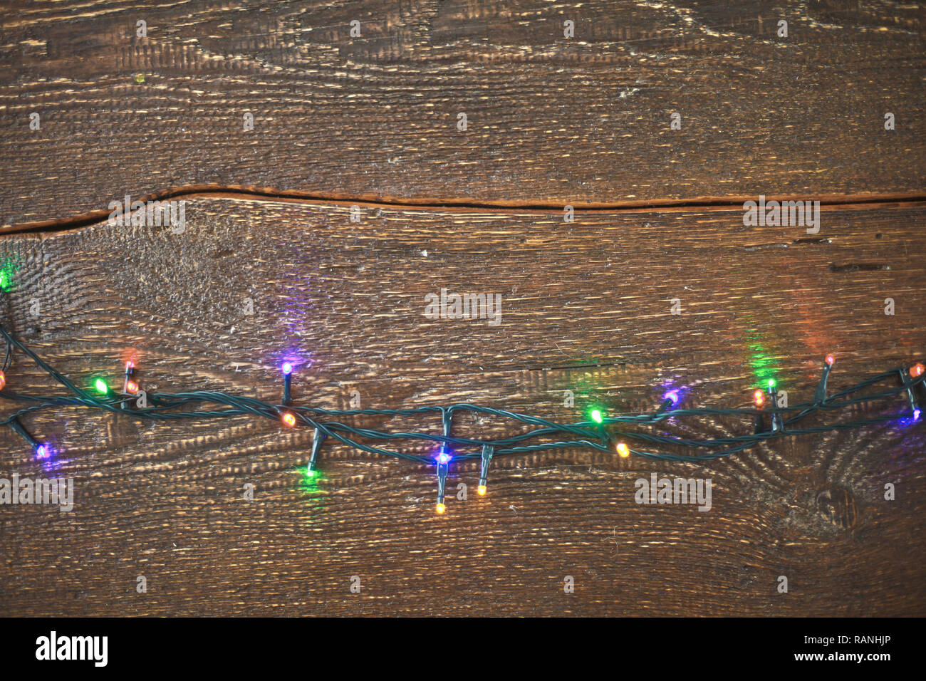 Christmas lights on a wooden background. View from above Stock Photo